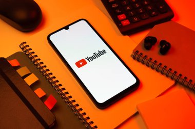 Prag, Çek Cumhuriyeti - 08 18 2025: Merkezde Youtube logosu sergilenen bir cep telefonu ile ofis malzemeleri düzenlemesi. Youtube dünya çapında videoları izlemek ve paylaşmak için bir platform.