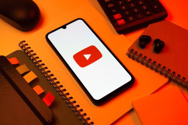 Prag, Çek Cumhuriyeti - 08 18 2025: Merkezde Youtube logosu sergilenen bir cep telefonu ile ofis malzemeleri düzenlemesi. Youtube dünya çapında videoları izlemek ve paylaşmak için bir platform.