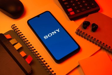 Prag, Çek Cumhuriyeti - 08 18 2025: Merkezde Sony logosunu gösteren bir cep telefonu ile ofis malzemeleri düzenlemesi. Sony elektronik, oyun ve eğlence üreten bir teknoloji şirketidir..