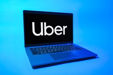 Prag, Çek Cumhuriyeti - 08 01 2025: Üniforma arka planda bir dizüstü bilgisayar Uber logosunu gösteriyor. Uber ulaşım ve dağıtım hizmetleri için bir gezinti selamlama uygulaması.