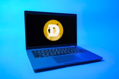 Prag, Çek Cumhuriyeti - 08 01 2025: Tek bir arkaplanda bir dizüstü bilgisayar Dogecoin logosunu gösteriyor. Dogecoin, paylaşımcı işlemler için kullanılan bir şifreli para birimidir.