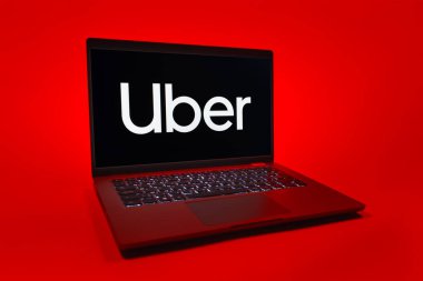 Prag, Çek Cumhuriyeti - 08 01 2025: Üniforma arka planda bir dizüstü bilgisayar Uber logosunu gösteriyor. Uber ulaşım ve dağıtım hizmetleri için bir gezinti selamlama uygulaması.