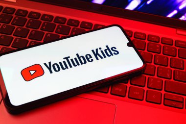 Prag, Çek Cumhuriyeti - 08 01 2025: Laptop klavyesinde duran bir cep telefonu Youtube Kids logosunu gösteriyor. Youtube Kids çocuk dostu video içeriği için bir platformdur.