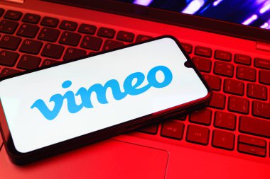 Prag, Çek Cumhuriyeti - 08 01 2025: Dizüstü bilgisayarın üzerinde duran bir cep telefonu Vimeo logosunu gösterir. Vimeo, yüksek kaliteli video sunucu ve paylaşımı için bir platformdur.