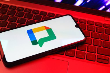 Prag, Çek Cumhuriyeti - 08 01 2025: Dizüstü bilgisayarın üzerinde duran bir cep telefonu Google Chat logosunu görüntüler. Google Chat mesajlaşma ve takım işbirliği için bir platformdur.