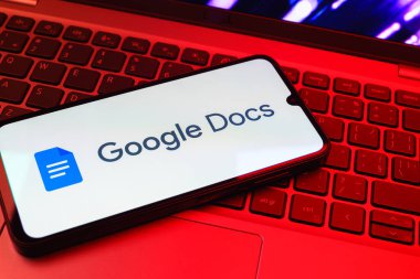 Prag, Çek Cumhuriyeti - 08 01 2025: Dizüstü bilgisayarda bulunan bir cep telefonu Google Docs logosunu görüntüler. Google Docs metin belgeleri oluşturmak ve düzenlemek için bir platformdur.