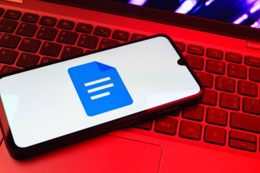 Prag, Çek Cumhuriyeti - 08 01 2025: Dizüstü bilgisayarda bulunan bir cep telefonu Google Docs logosunu görüntüler. Google Docs metin belgeleri oluşturmak ve düzenlemek için bir platformdur.