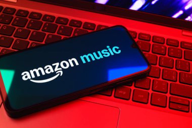 Prag, Çek Cumhuriyeti - 08 01 2025: Laptop klavyesinde uzanan bir cep telefonu Amazon Müzik logosunu gösteriyor. Amazon Müzik müzik müzik için bir platformdur..