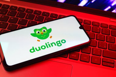 Prag, Çek Cumhuriyeti - 08 01 2025: Klavyenin üzerinde duran bir cep telefonu Duolingo logosunu gösteriyor. Duolingo interaktif olarak dil öğrenmek için bir platformdur..