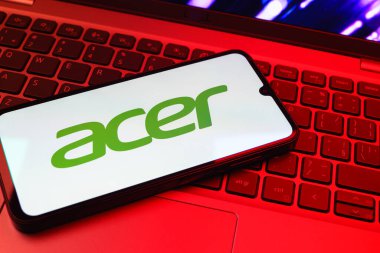 Prag, Çek Cumhuriyeti - 08 01 2025: Dizüstü bilgisayarın üzerinde duran bir cep telefonu Acer logosunu gösterir. Acer bilgisayar ve elektronik üreten bir teknoloji şirketidir..