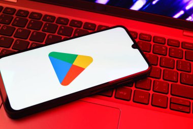 Prag, Çek Cumhuriyeti - 08 01 2025: Dizüstü bilgisayarda bulunan bir cep telefonu Google Play logosunu görüntüler. Google Play uygulamaları, oyunları ve dijital içeriği indirmek için bir platformdur.