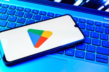 Prag, Çek Cumhuriyeti - 08 01 2025: Dizüstü bilgisayarda bulunan bir cep telefonu Google Play logosunu görüntüler. Google Play uygulamaları, oyunları ve dijital içeriği indirmek için bir platformdur.