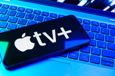 Prag, Çek Cumhuriyeti - 08 01 2025: Laptop klavyesinde uzanan bir cep telefonu Apple TV + logosunu gösteriyor. Apple TV +, filmler ve TV programları için bir yayın platformudur..