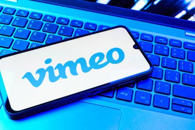 Prag, Çek Cumhuriyeti - 08 01 2025: Dizüstü bilgisayarın üzerinde duran bir cep telefonu Vimeo logosunu gösterir. Vimeo, yüksek kaliteli video sunucu ve paylaşımı için bir platformdur.