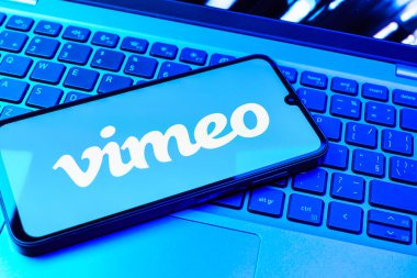 Prag, Çek Cumhuriyeti - 08 01 2025: Dizüstü bilgisayarın üzerinde duran bir cep telefonu Vimeo logosunu gösterir. Vimeo, yüksek kaliteli video sunucu ve paylaşımı için bir platformdur.