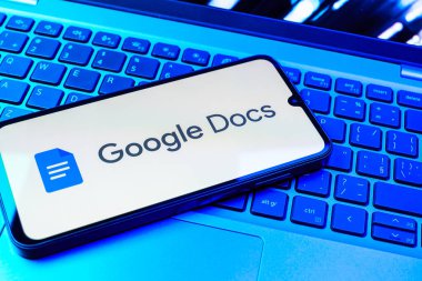Prag, Çek Cumhuriyeti - 08 01 2025: Dizüstü bilgisayarda bulunan bir cep telefonu Google Docs logosunu görüntüler. Google Docs metin belgeleri oluşturmak ve düzenlemek için bir platformdur.