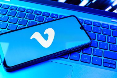 Prag, Çek Cumhuriyeti - 08 01 2025: Dizüstü bilgisayarın üzerinde duran bir cep telefonu Vimeo logosunu gösterir. Vimeo, yüksek kaliteli video sunucu ve paylaşımı için bir platformdur.