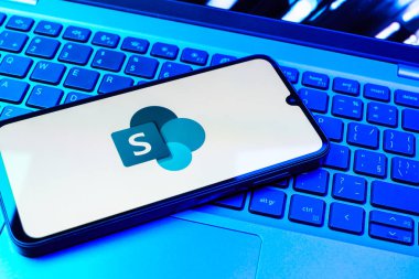 Prag, Çek Cumhuriyeti - 08 01 2025: Dizüstü bilgisayarın üzerinde duran bir cep telefonu Microsoft Sharepoint logosunu gösteriyor. Microsoft Sharepoint işbirliği ve belge yönetimi için bir platformdur.