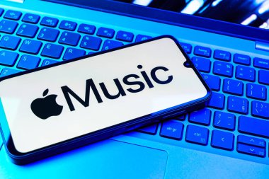 Prag, Çek Cumhuriyeti - 08 01 2025: Laptop klavyesinde uzanan bir cep telefonu Apple Music logosunu gösteriyor. Apple Music müzik için bir platformdur..