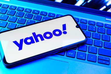 Prag, Çek Cumhuriyeti - 08 01 2025: Laptop klavyesinde duran bir cep telefonu Yahoo logosunu gösteriyor. Yahoo haber, e-posta ve internet hizmetleri için bir platformdur..