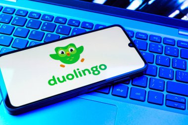 Prag, Çek Cumhuriyeti - 08 01 2025: Klavyenin üzerinde duran bir cep telefonu Duolingo logosunu gösteriyor. Duolingo interaktif olarak dil öğrenmek için bir platformdur..