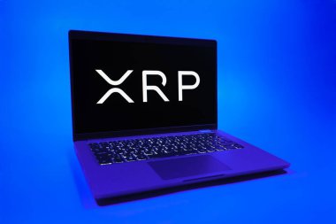 Prag, Çek Cumhuriyeti - 08 01 2025: Tek tip arkaplanda bir dizüstü bilgisayar Ripple logosunu gösterir. Dalgalanma dijital kripto para birimi ve ödeme protokolüdür..