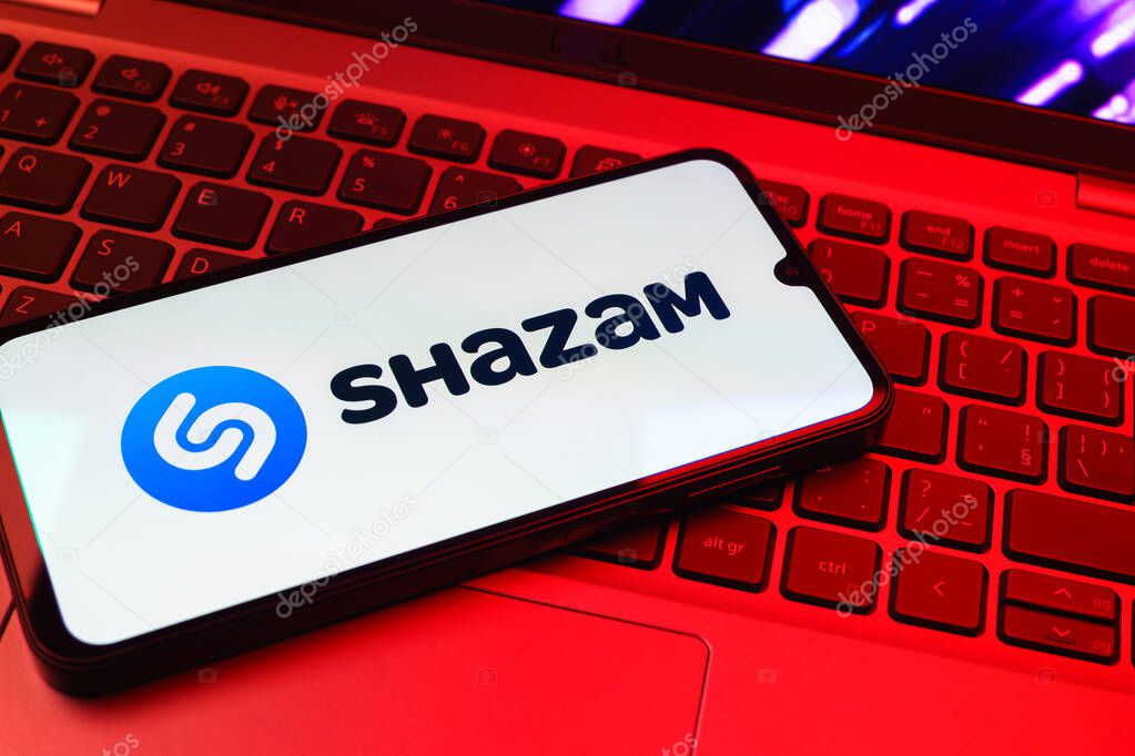 Prague, Czechia - 08 01 2025: A mobile phone lying on a laptop keyboard displays the Shazam logo. Shazam is an app for identifying songs and music tracks.