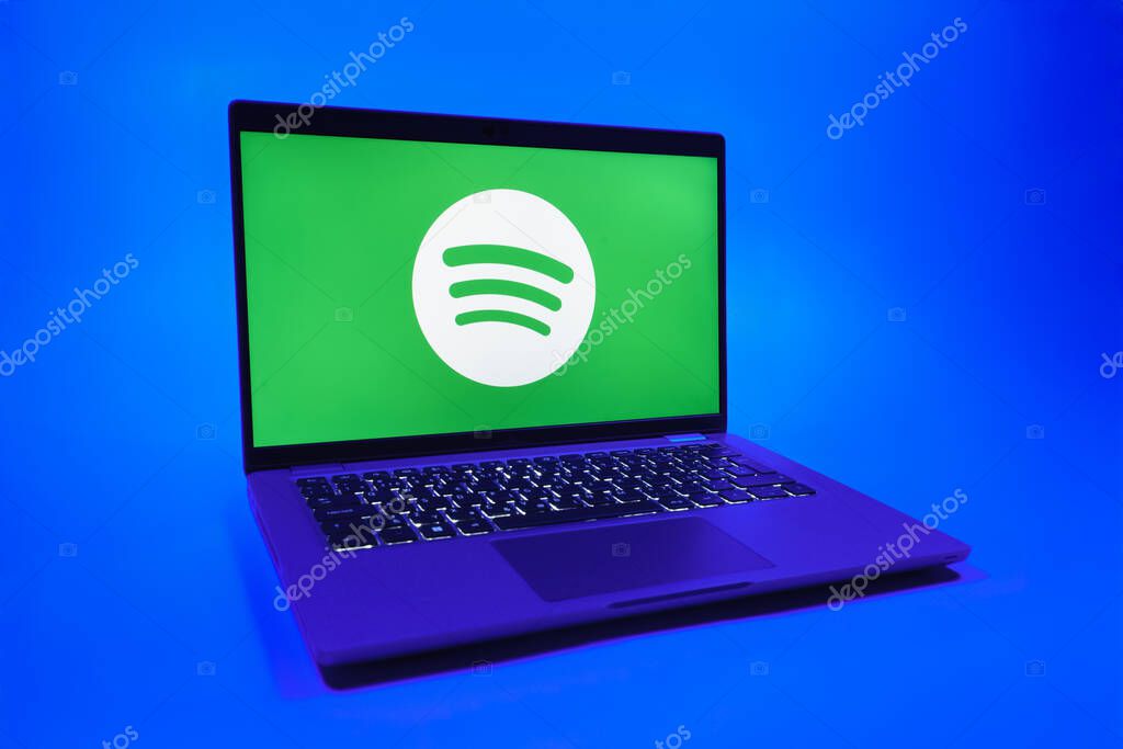 Prague, Czechia - 08 01 2025: A laptop on a uniform background displays the Spotify logo. Spotify is a platform for streaming and discovering music.