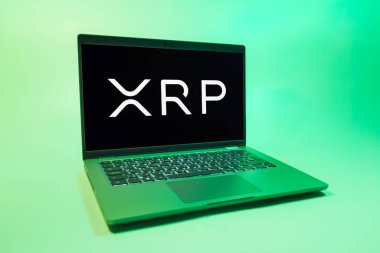 Prag, Çek Cumhuriyeti - 08 01 2025: Tek tip arkaplanda bir dizüstü bilgisayar Ripple logosunu gösterir. Dalgalanma dijital kripto para birimi ve ödeme protokolüdür..