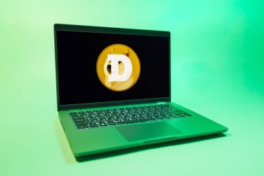 Prag, Çek Cumhuriyeti - 08 01 2025: Tek bir arkaplanda bir dizüstü bilgisayar Dogecoin logosunu gösteriyor. Dogecoin, paylaşımcı işlemler için kullanılan bir şifreli para birimidir.