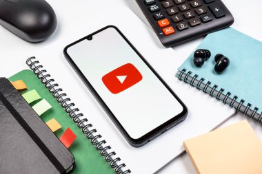 Prag, Çek Cumhuriyeti - 08 18 2025: Merkezde Youtube logosu sergilenen bir cep telefonu ile ofis malzemeleri düzenlemesi. Youtube dünya çapında videoları izlemek ve paylaşmak için bir platform.