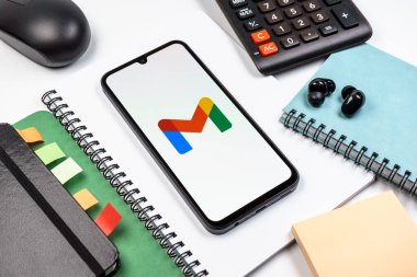 Prag, Çek Cumhuriyeti - 08 18 2025: Merkezde Google Gmail logosunu gösteren bir cep telefonu ile ofis malzemeleri düzenlemesi. Google Gmail, mesaj göndermek ve almak için kullanılan bir e-posta servisidir..