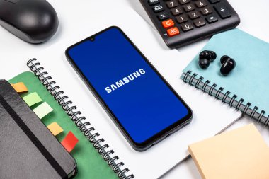 Prag, Çek Cumhuriyeti - 08 18 2025: Merkezde Samsung logosu sergilenen bir cep telefonu ile ofis malzemeleri düzenlemesi. Samsung elektronik ve cihaz üreten bir teknoloji şirketi..