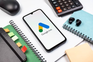Prag, Çek Cumhuriyeti - 08 18 2025: Merkezde Google Ads logosunu gösteren bir cep telefonu ile ofis malzemeleri düzenlemesi. Google Reklamları, çevrimiçi reklamlar yaratmak ve yönetmek için bir platformdur.