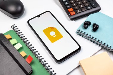 Prag, Çek Cumhuriyeti - 08 18 2025: Merkezde Google Keep logosu sergilenen bir cep telefonu ile ofis malzemeleri düzenlemesi. Google Keep notlar, listeler ve hatırlatıcılar için bir platformdur.