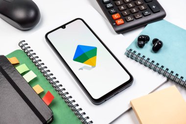 Prag, Çek Cumhuriyeti - 08 18 2025: Merkezde Google Family Link logosunu gösteren bir cep telefonu ile ofis malzemeleri düzenlemesi. Google Family Link ebeveyn denetimi ve çocuk hesabı yönetimi için bir platformdur.