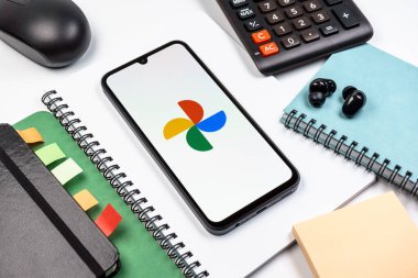 Prag, Çek Cumhuriyeti - 08 18 2025: Merkezde Google Photos logosunu gösteren bir cep telefonu ile ofis malzemeleri düzenlemesi. Google Fotoğrafları fotoğraf ve videoları saklamak ve düzenlemek için bir platformdur.