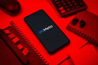 Prag, Çek Cumhuriyeti - 08 18 2025: Merkezde Meta logosunu gösteren bir cep telefonu ile ofis malzemeleri düzenlemesi. Meta, Facebook ve Instagram gibi sosyal platformlar sunan bir şirket..