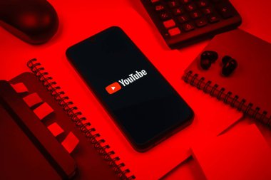 Prag, Çek Cumhuriyeti - 08 18 2025: Merkezde Youtube logosu sergilenen bir cep telefonu ile ofis malzemeleri düzenlemesi. Youtube dünya çapında videoları izlemek ve paylaşmak için bir platform.