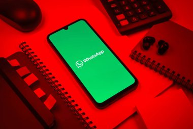 Prag, Çek Cumhuriyeti - 08 18 2025: Ofis malzemelerinin merkezde WhatsApp logosunu gösteren bir cep telefonu ile düzenlenmesi. WhatsApp mesaj, çağrı ve medya göndermek için bir uygulamadır.