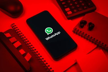 Prag, Çek Cumhuriyeti - 08 18 2025: Ofis malzemelerinin merkezde WhatsApp logosunu gösteren bir cep telefonu ile düzenlenmesi. WhatsApp mesaj, çağrı ve medya göndermek için bir uygulamadır.