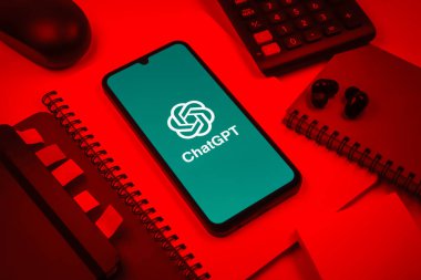 Prag, Çek Cumhuriyeti - 08 18 2025: Merkezinde ChatGPT logosu bulunan bir cep telefonu ile ofis malzemeleri düzenlemesi. ChatGPT metin üretmek ve soruları cevaplamak için bir yapay zeka sohbet robotudur..