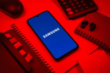 Prag, Çek Cumhuriyeti - 08 18 2025: Merkezde Samsung logosu sergilenen bir cep telefonu ile ofis malzemeleri düzenlemesi. Samsung elektronik ve cihaz üreten bir teknoloji şirketi..
