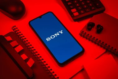 Prag, Çek Cumhuriyeti - 08 18 2025: Merkezde Sony logosunu gösteren bir cep telefonu ile ofis malzemeleri düzenlemesi. Sony elektronik, oyun ve eğlence üreten bir teknoloji şirketidir..