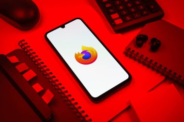 Prag, Çek Cumhuriyeti - 08 18 2025: Merkezde Firefox logosunu gösteren bir cep telefonu ile ofis malzemeleri düzenlemesi. Firefox hızlı ve güvenli internet taraması için bir web tarayıcısıdır.