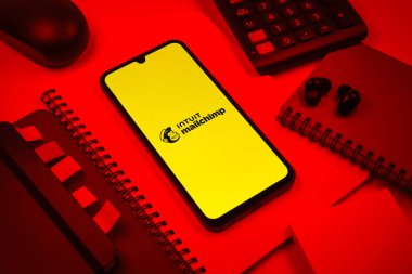 Prag, Çek Cumhuriyeti - 08 18 2025: Posta şempanzesinin logosunu gösteren bir cep telefonu ile ofis malzemeleri düzenlemesi. Posta şempanzesi e-posta pazarlama ve otomasyon için bir platformdur.