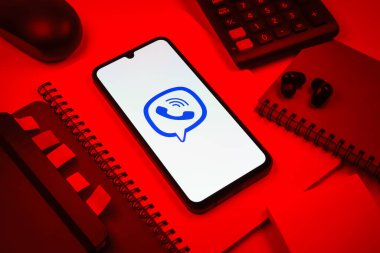 Prag, Çek Cumhuriyeti - 08 18 2025: Merkezde Viber logosunu gösteren bir cep telefonu ile ofis malzemeleri düzenlemesi. Viber aramalar, mesajlar ve medya paylaşımı için bir mesajlaşma uygulamasıdır.