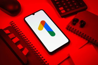 Prag, Çek Cumhuriyeti - 08 18 2025: Merkezinde Google One logosu bulunan bir cep telefonu ile ofis malzemeleri düzenlemesi. Google 1 bulut depolama ve abonelik hizmetleri için bir platformdur.
