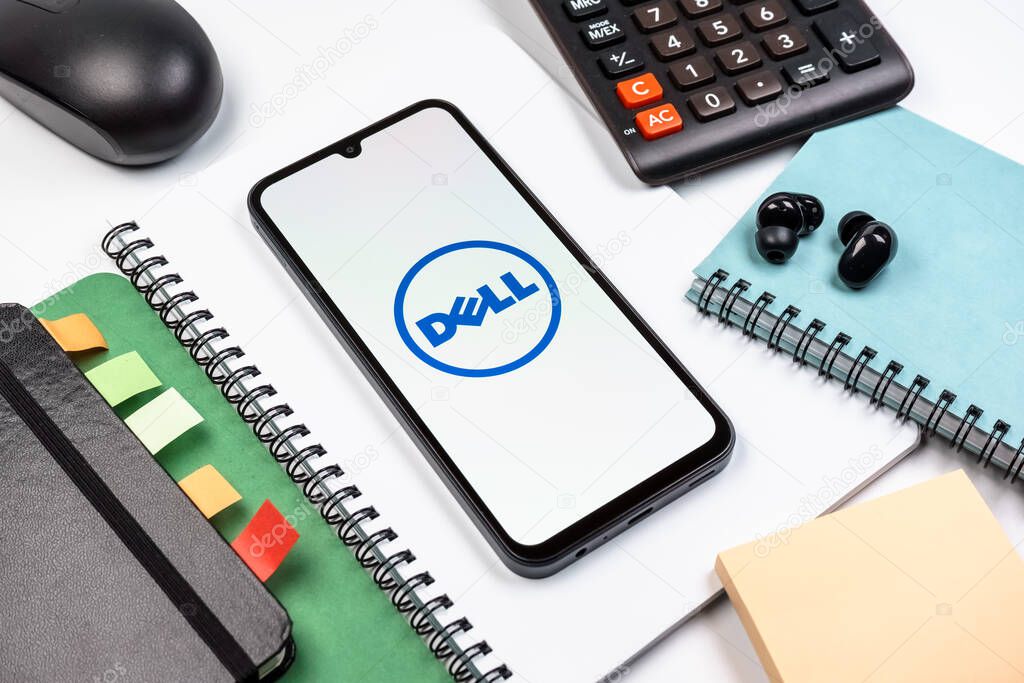 Prague, Czechia - 08 18 2025: An arrangement of office supplies with a mobile phone in the center displaying Dell logo. Dell is a technology company producing computers and IT solutions.