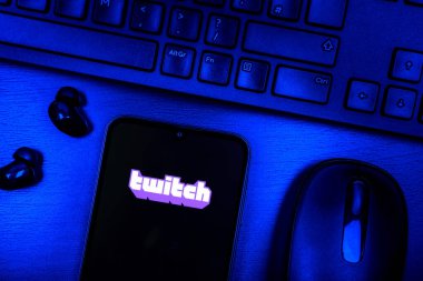 Prague, Czechia - 08 09 2025: A top-down view of a desk with a phone displaying the Twitch logo. Twitch is a platform for live streaming games and content.